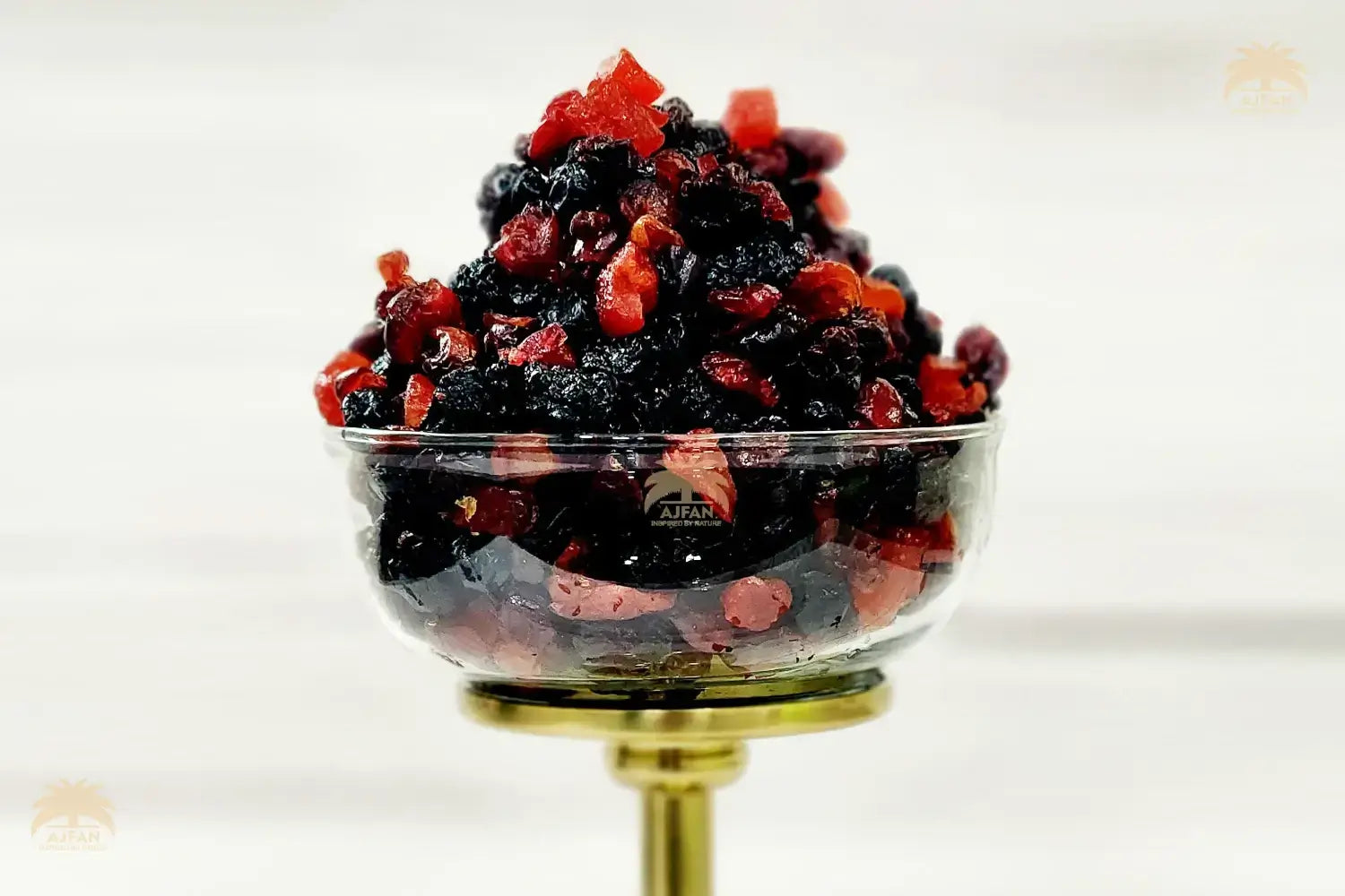 Glass bowl filled with black and red berries on a white background